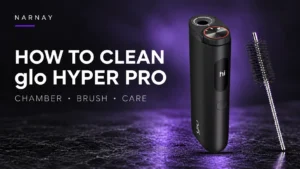 Black glo HYPER PRO device beside its cleaning brush on a dark background with purple lighting.