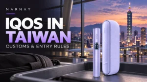 Purple IQOS ILUMA i device and charging case on an airport tray, with Taipei 101 in the background.